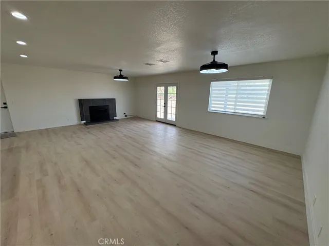 an empty room with windows and fireplace