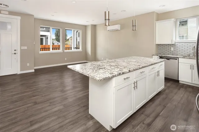 a kitchen with stainless steel appliances granite countertop a white stove top oven and white cabinets with wooden floor