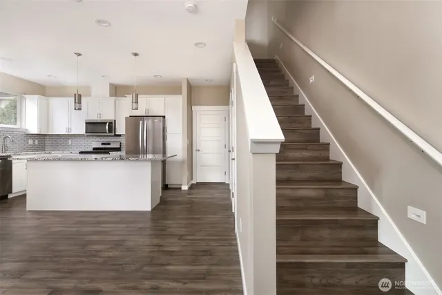 a view of kitchen with wooden floor and electronic appliances