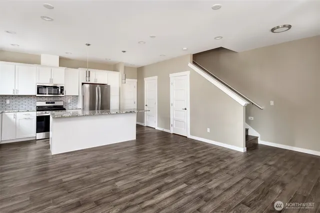 a view of kitchen with wooden floor and electronic appliances