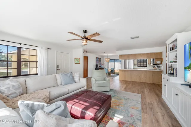a living room with furniture and hard wood flooring