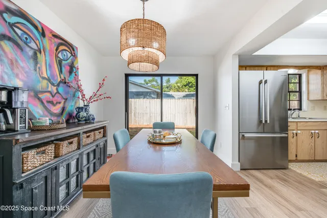 a kitchen with stainless steel appliances granite countertop a refrigerator a stove and a dining table with wooden floor