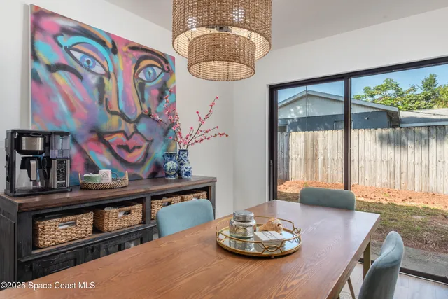 a view of a dining room with furniture a chandelier and wooden floor
