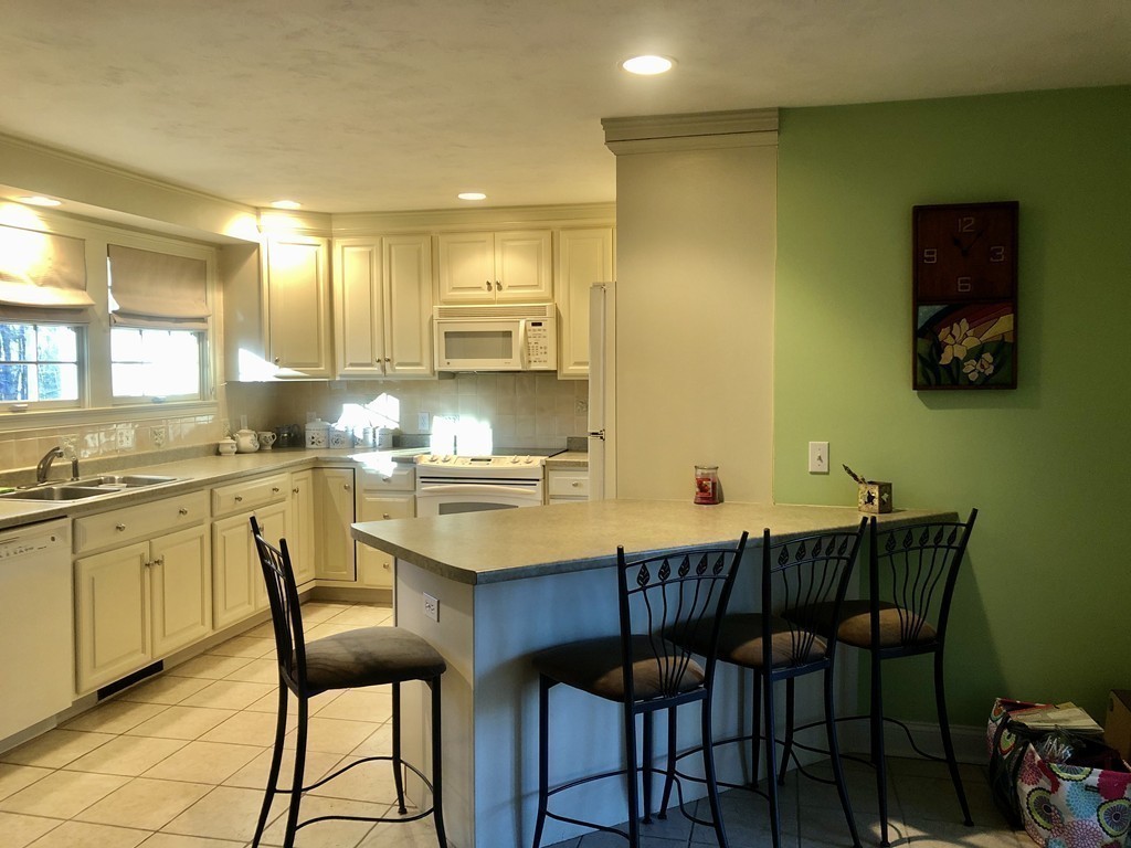 355 Maple Street West Boylston, MA 01583 - Photo 25 of 42 a kitchen with a dining table chairs and white cabinets