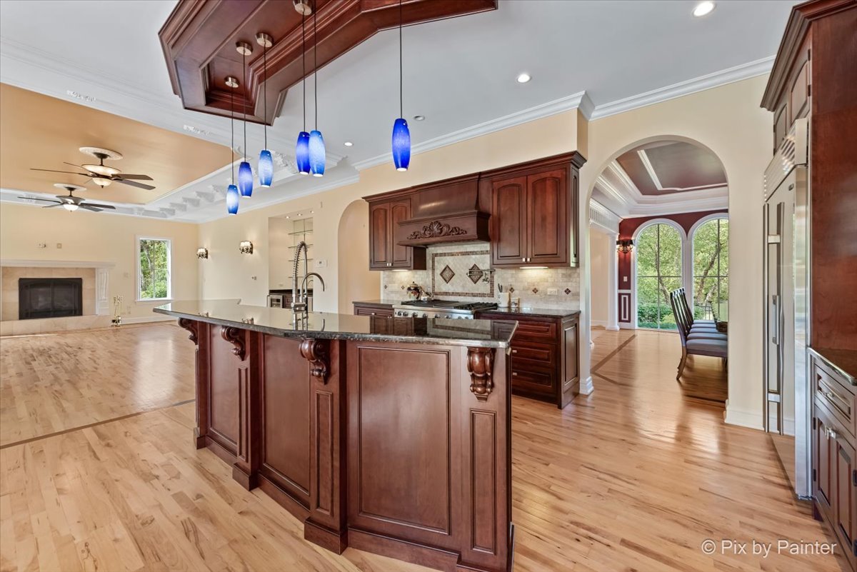 27 West Onwentsia Road Lake Forest, IL 60045 - Photo 22 of 84 a kitchen with stainless steel appliances granite countertop a refrigerator a sink dishwasher a stove and a dining table with wooden floor