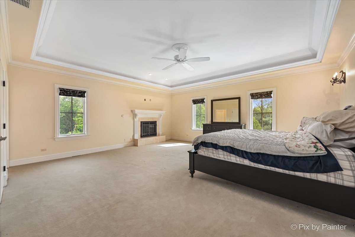 27 West Onwentsia Road Lake Forest, IL 60045 - Photo 49 of 84 a bed sitting in a spacious bedroom next to a window and a chandelier