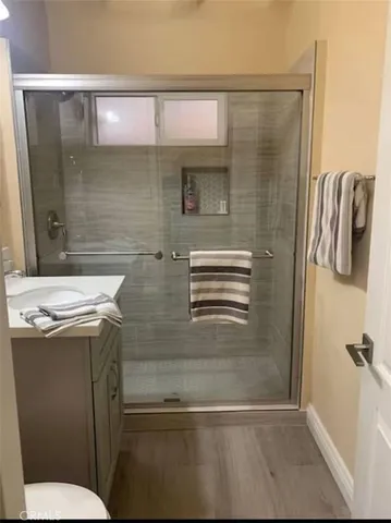 a bathroom with a granite countertop sink toilet and shower
