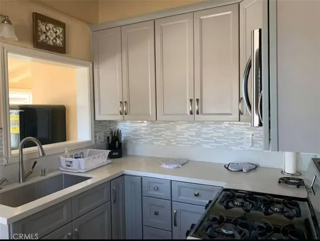a kitchen with a sink stove and cabinets