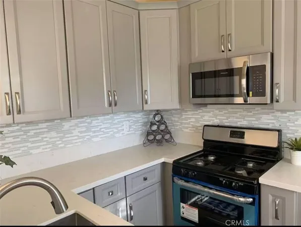 a kitchen with granite countertop white cabinets and stainless steel appliances