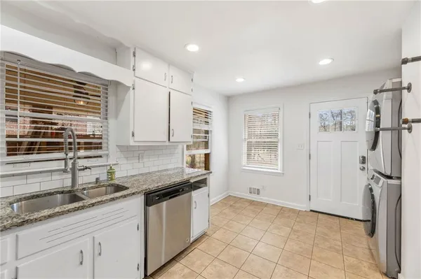 a kitchen with granite countertop a sink stainless steel appliances and cabinets