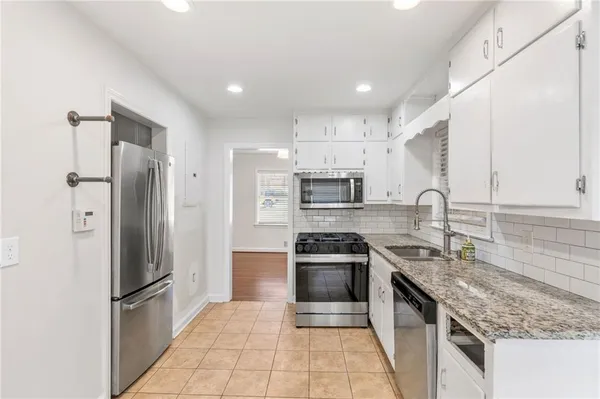 a kitchen with stainless steel appliances granite countertop a refrigerator stove and sink