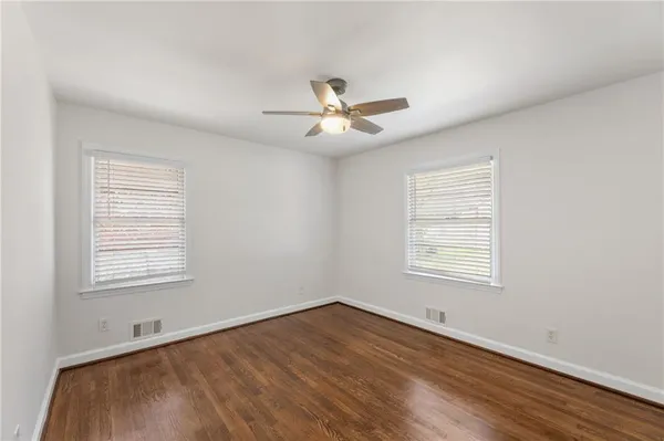 a view of an empty room with a window and a chandelier fan