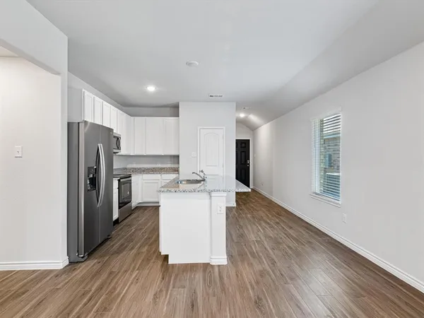 a kitchen with stainless steel appliances a refrigerator and a stove top oven