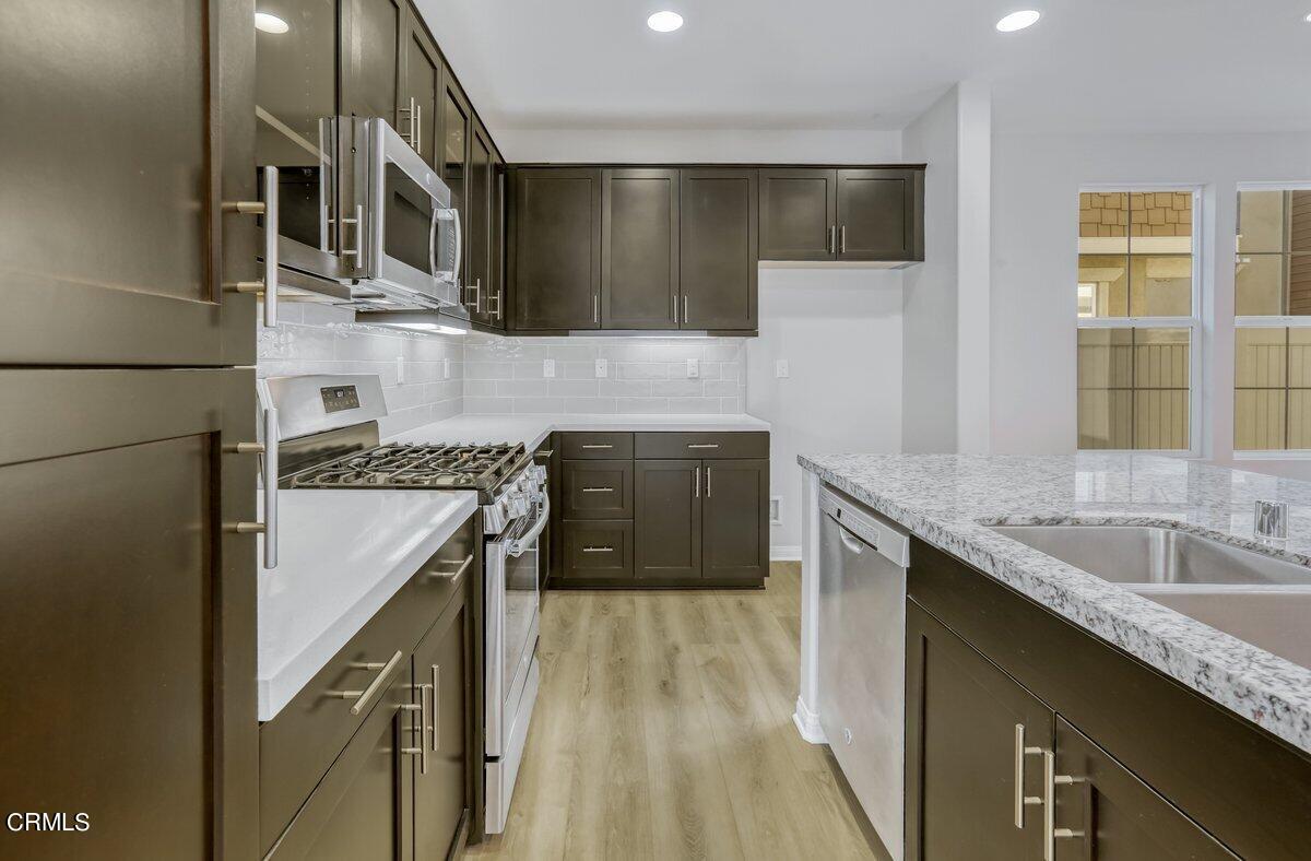 225 Stonegate Road Camarillo, CA 93010 - Photo 11 of 32 a kitchen with granite countertop a sink a stove and cabinets