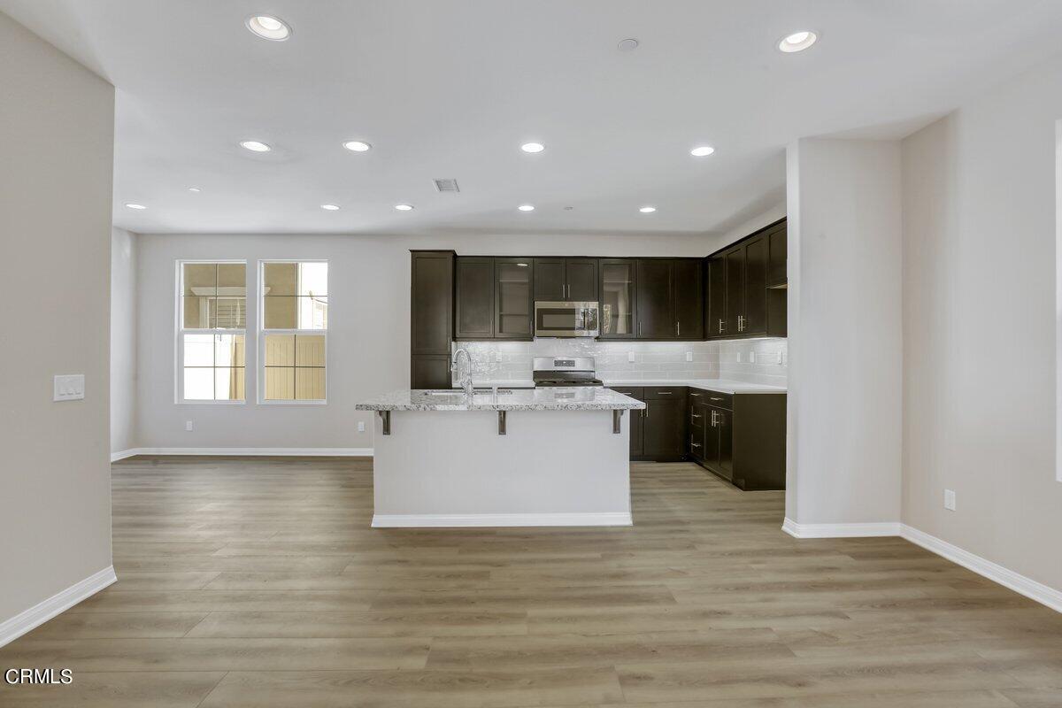 225 Stonegate Road Camarillo, CA 93010 - Photo 8 of 32 a view of kitchen with kitchen island a sink wooden floor and a living room view