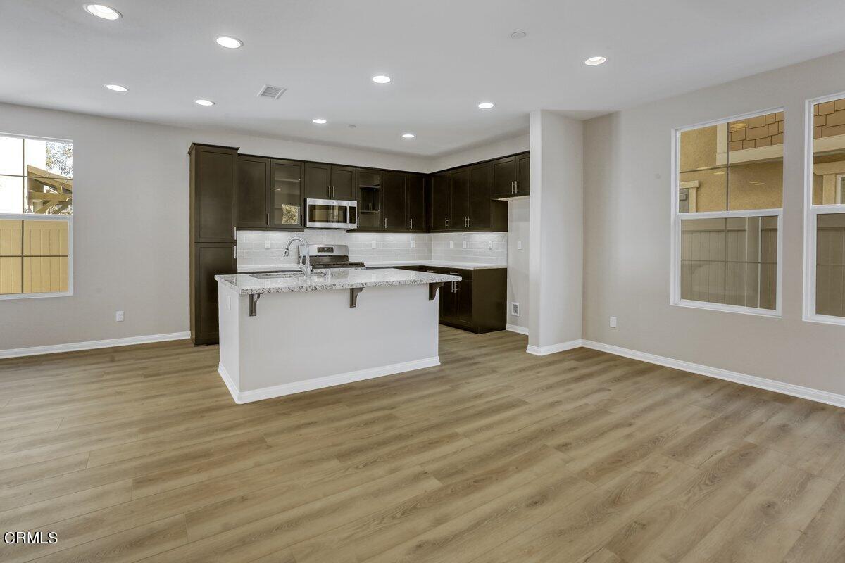225 Stonegate Road Camarillo, CA 93010 - Photo 9 of 32 a view of kitchen with kitchen island a sink wooden floor and a refrigerator