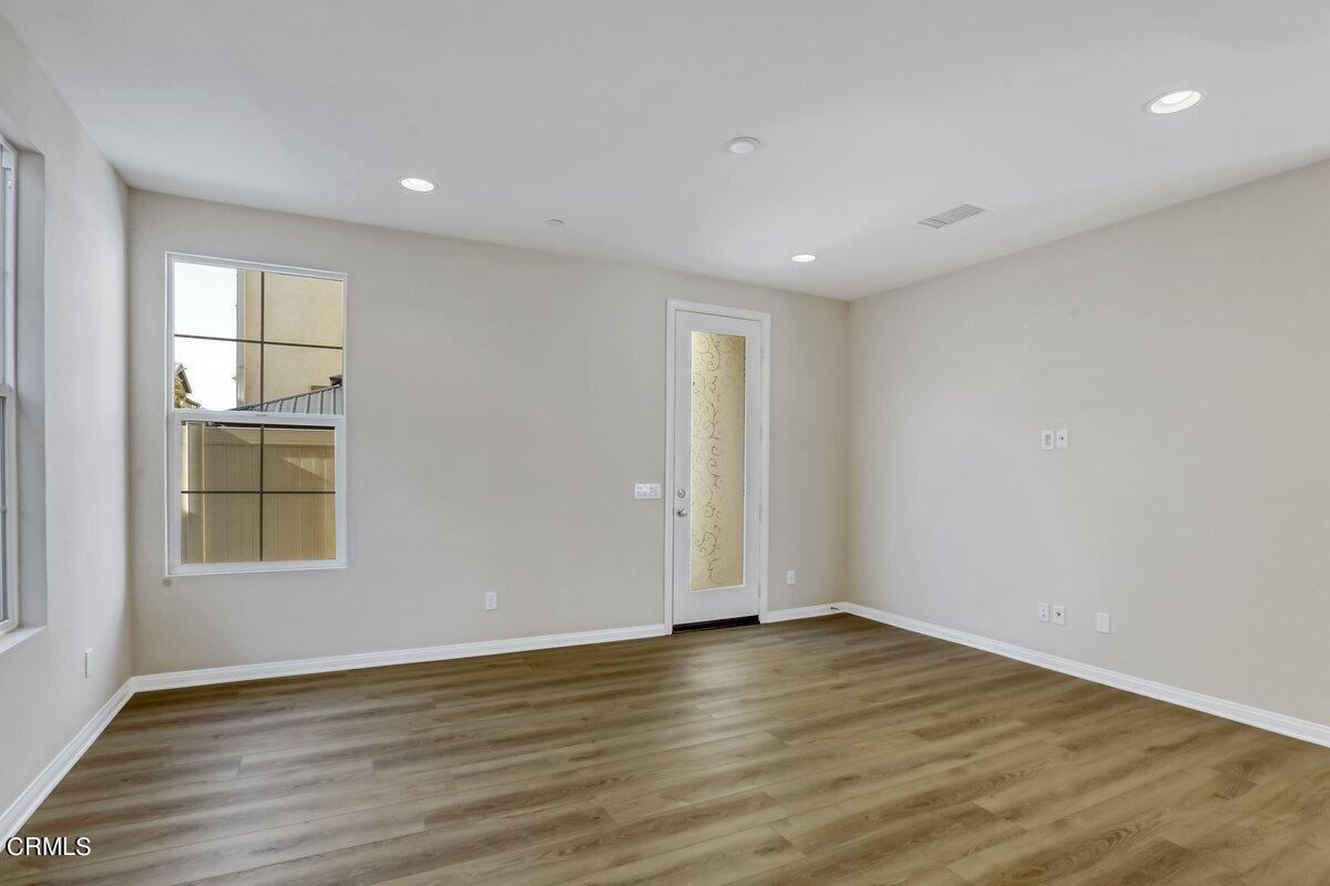 225 Stonegate Road Camarillo, CA 93010 - Photo 10 of 32 an empty room with wooden floor and windows