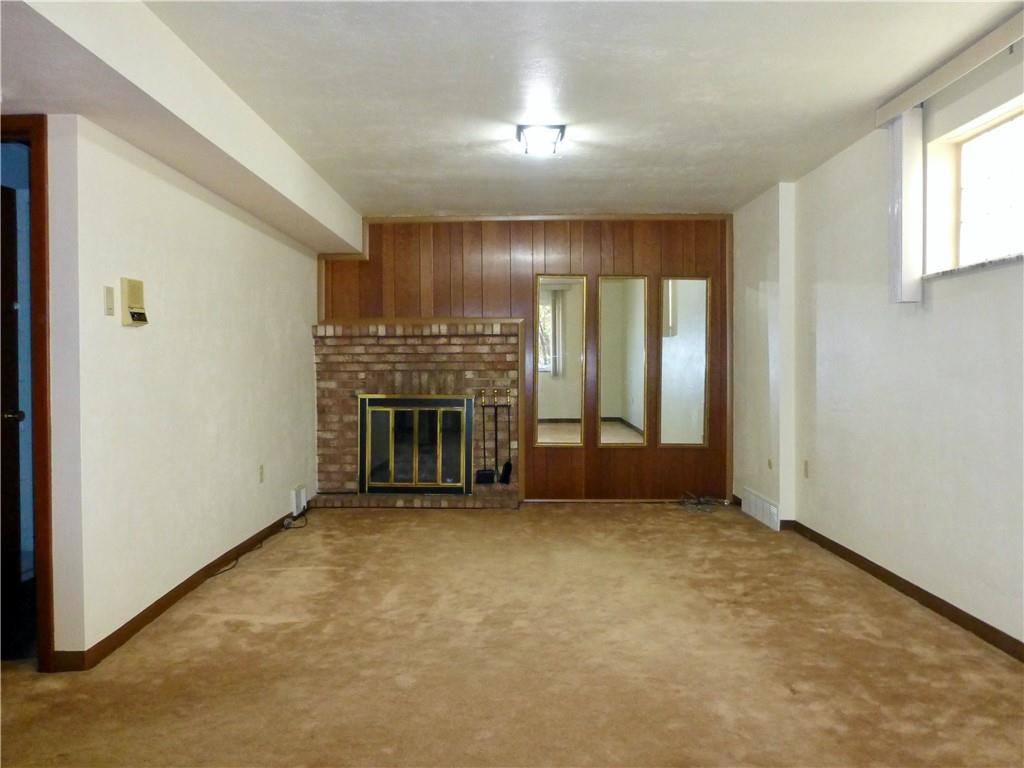 34 Roxbury Road Pittsburgh, PA 15221 - Photo 4 of 27 The family room has wall-to-wall carpet and a gas fireplace.