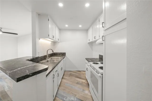 a kitchen with granite countertop a sink and cabinets