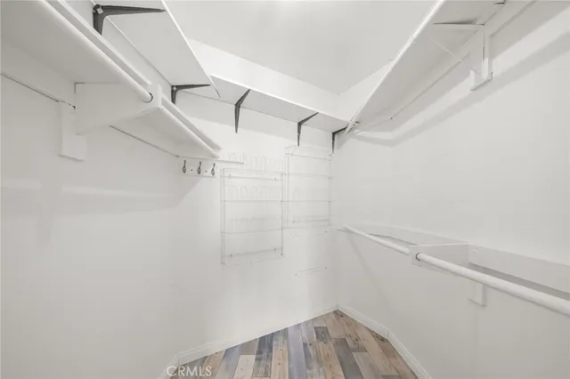 a view of a big room with wooden floor and windows