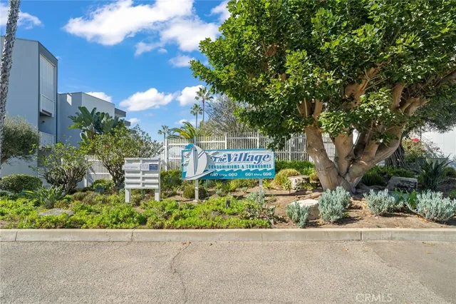 a view of sign board with flower plants and wooden fence