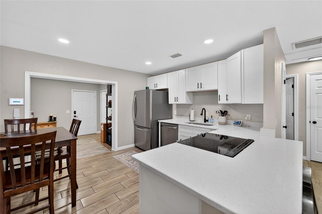 5502 Peach Avenue Seffner, FL 33584 - Photo 19 of 48 a kitchen with a table chairs refrigerator and cabinets