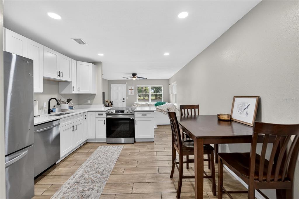 5502 Peach Avenue Seffner, FL 33584 - Photo 23 of 48 a large kitchen with stainless steel appliances granite countertop a stove a sink a dining table and chairs