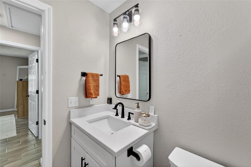 5502 Peach Avenue Seffner, FL 33584 - Photo 31 of 48 a bathroom with a toilet sink and mirror