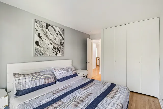 a bedroom with a bed and a window with wooden floor