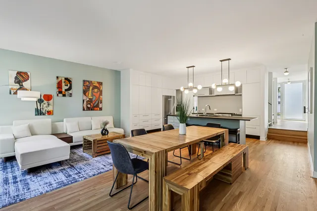 a living room with furniture a flat screen tv and kitchen view