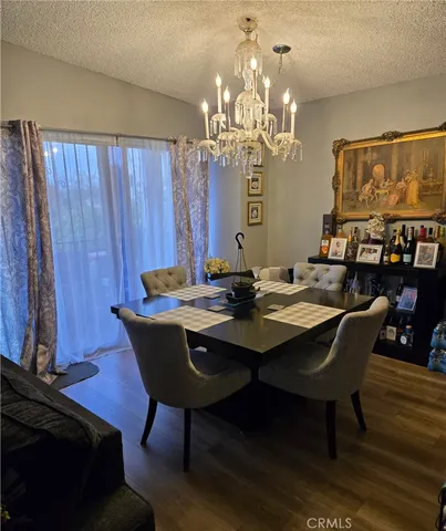 a view of a dining room with furniture a chandelier and wooden floor