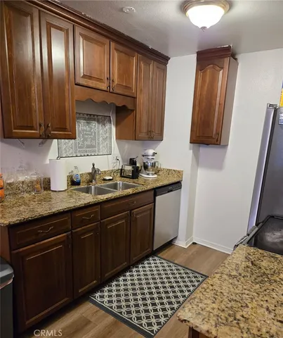a kitchen with granite countertop wooden cabinets and a stove top oven