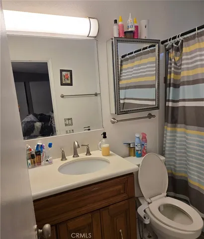 a bathroom with a sink vanity mirror and toilet