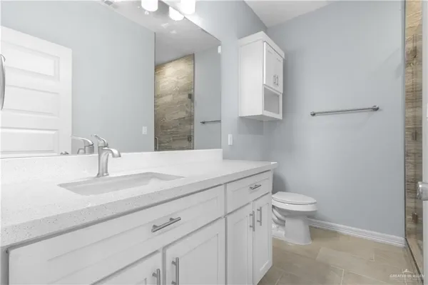 a bathroom with a granite countertop toilet and sink