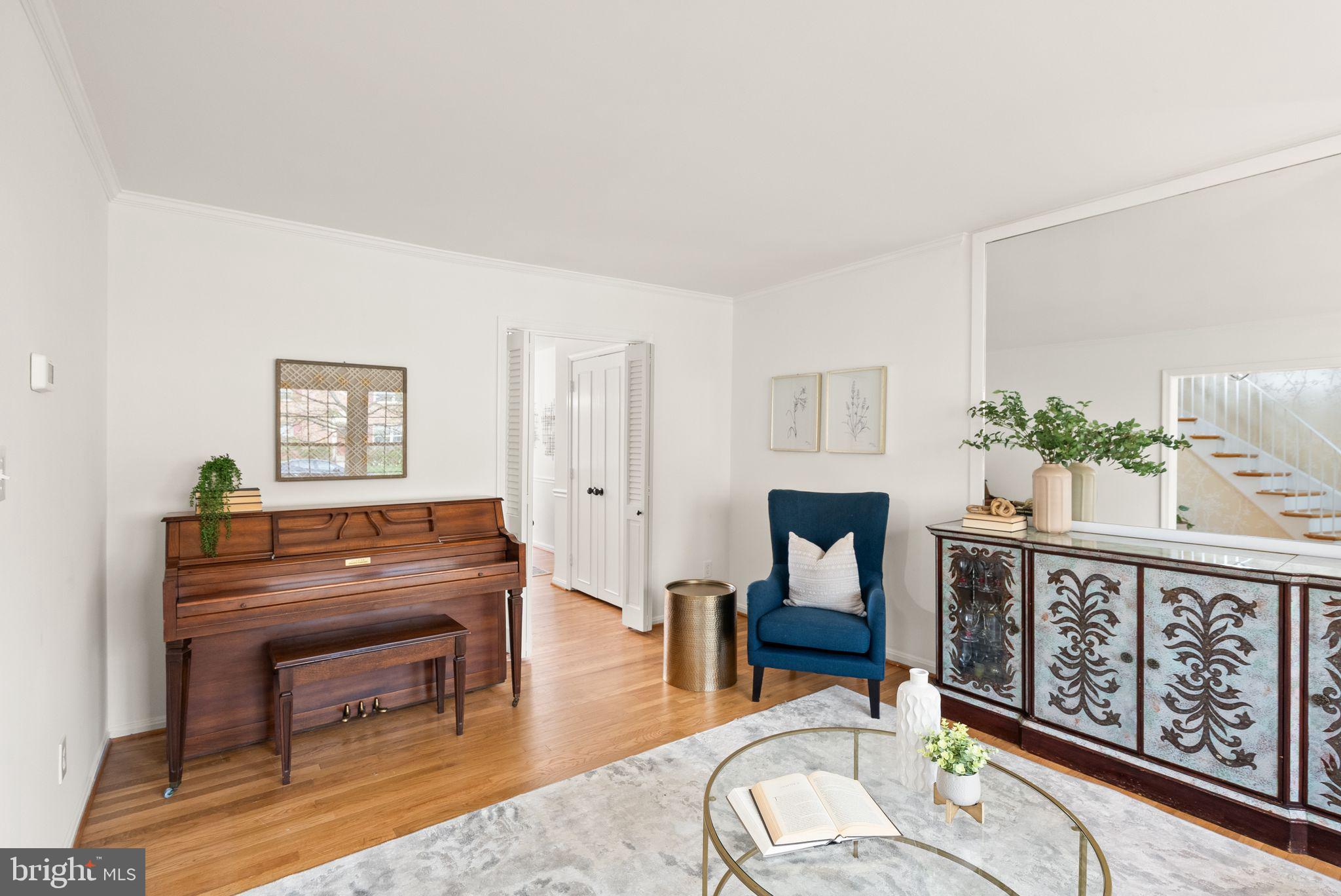 6026 Queenston Street Springfield, VA 22152 - Photo 6 of 53 a living room with furniture a fireplace and paintings on the wall