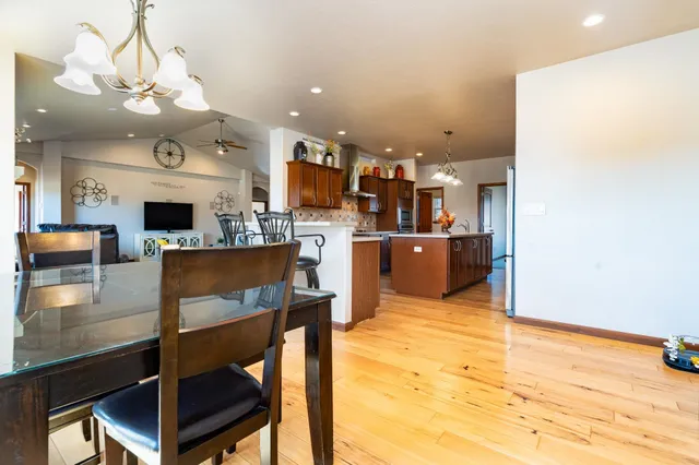 a view of a dining room with furniture a kitchen and chandelier