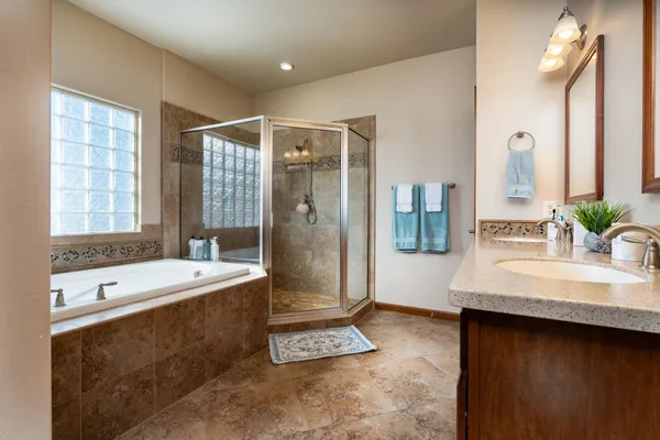 a spacious bathroom with a tub sink and mirror