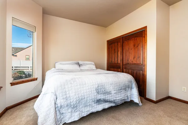 a bedroom with a bed and large window
