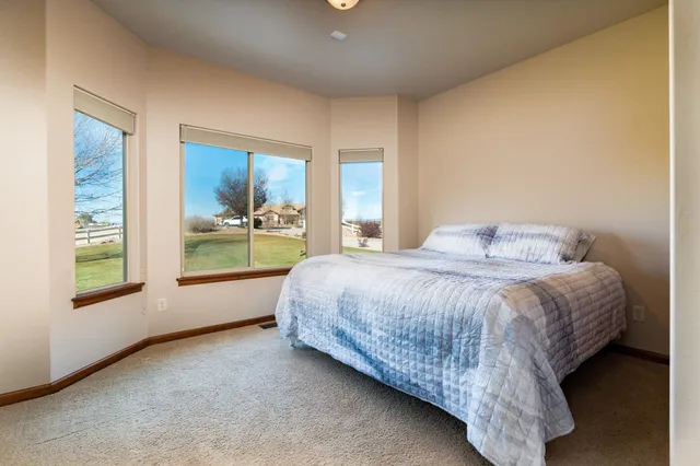 a spacious bedroom with a bed and a large window
