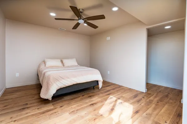 a bedroom with a bed and a ceiling fan