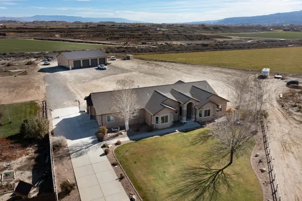an aerial view of a house with pool and lake view