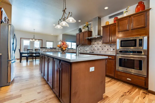 a kitchen with stainless steel appliances granite countertop a stove refrigerator and a microwave