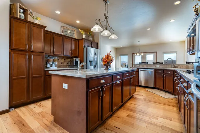 a kitchen with stainless steel appliances granite countertop counter space a sink a window and wooden floor
