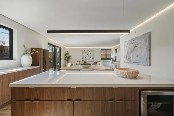 a living room with stainless steel appliances kitchen island a table and chairs