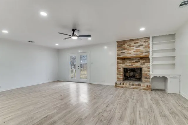 an empty room with a fireplace and window