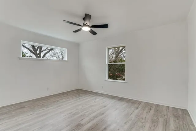 a view of empty room with wooden floor