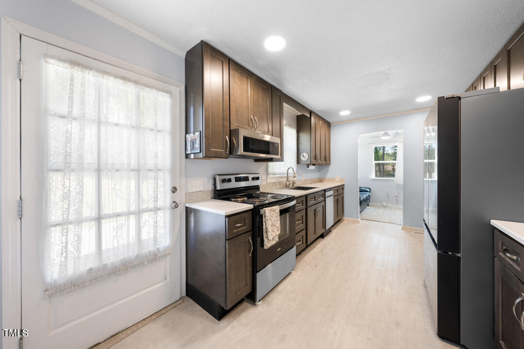 916 Clayton Road Durham, NC 27703 - Photo 4 of 32 a kitchen with stainless steel appliances granite countertop a refrigerator a stove top oven a sink and dishwasher