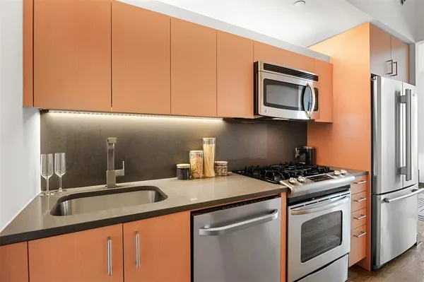 a kitchen with stainless steel appliances granite countertop a sink stove and microwave