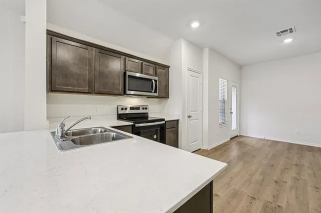 a kitchen with granite countertop a sink and a stove top oven