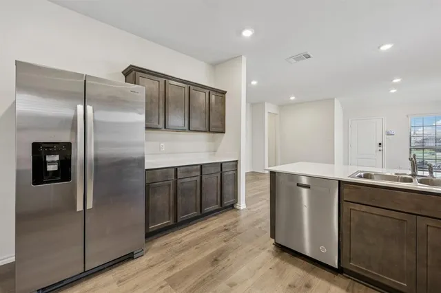 a kitchen with stainless steel appliances granite countertop a refrigerator a sink and a stove